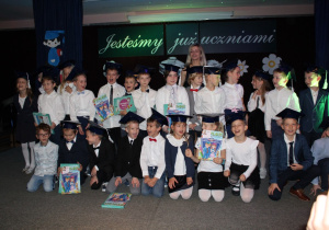 Wspólne zdjęcie dzieci z klasy 1 c z wychowawcą i pamiątkowymi dyplomami.