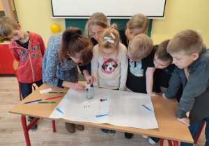 Uczniowie obserwują doświadczenie mianem chromatografii. Pozwala ono rozdzielić barwniki zawarte w pisakach na poszczególne kolory, z jakich się składają.