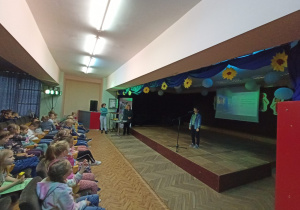 Na zdjęciu widoczne są dzieci oglądające podsumowanie konkursu recytatorskiego.