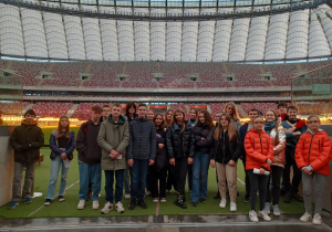 Zdjęcie grupowe klasy 8c, młodzież stoi na płycie stadionu i pozuje do wspólnej fotografii.