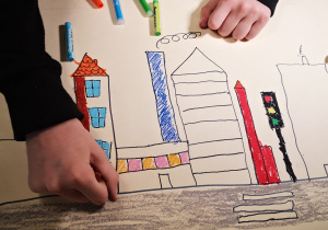 Dziecko wykonujące rysunek na kartonie.