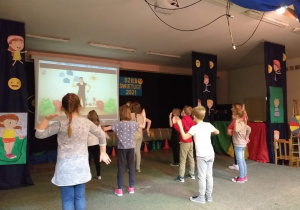 Dzieci wykonujące układ taneczny na scenie.