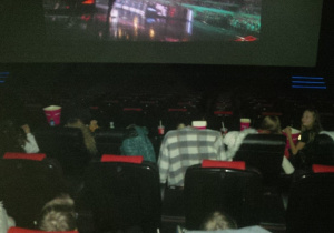 Dzieci oglądające film w sali kinowanej.