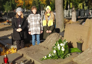 Trzy uczennice stoją przy grobie prof. Jana Molla.