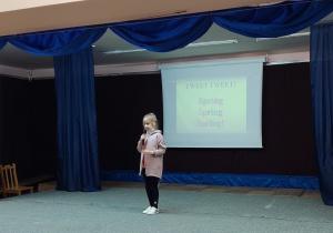 Ta sama dziewczynka na scenie na tle napisu spring, spring, spring.