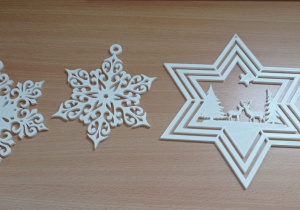 Na blacie widoczne są dwa płatki śniegu oraz gwiazda z wpisanym obrazkiem.