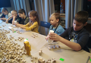 Dzieci sklejające drewniane klocki.