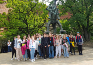 Grupa uczniów, w tle pomnik smoka wawelskiego.