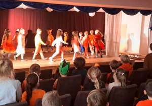 Dzieci na scenie prezentują jesienne stylizacje.