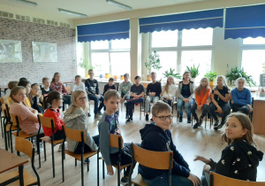 Uczniowie siedzący w sali lekcyjnej podczas warsztatów.