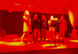 Dziewczynki stoją na scenie i śpiewają piosenkę.