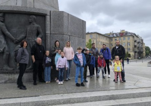 Grupa uczestników rajdu pozuje do zdjęcia przy pomniku Tadeusza Kościuszki.