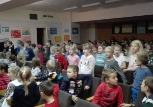 Dzieci siedzące na widowni i oglądające przedstawienie.