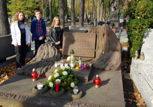 Troje uczniów stojących przy grobie Jana Witolda Molla.