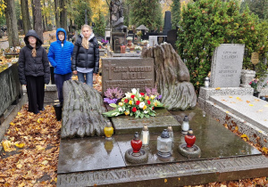 Delegacja trojga uczniów przy pomniku patrona